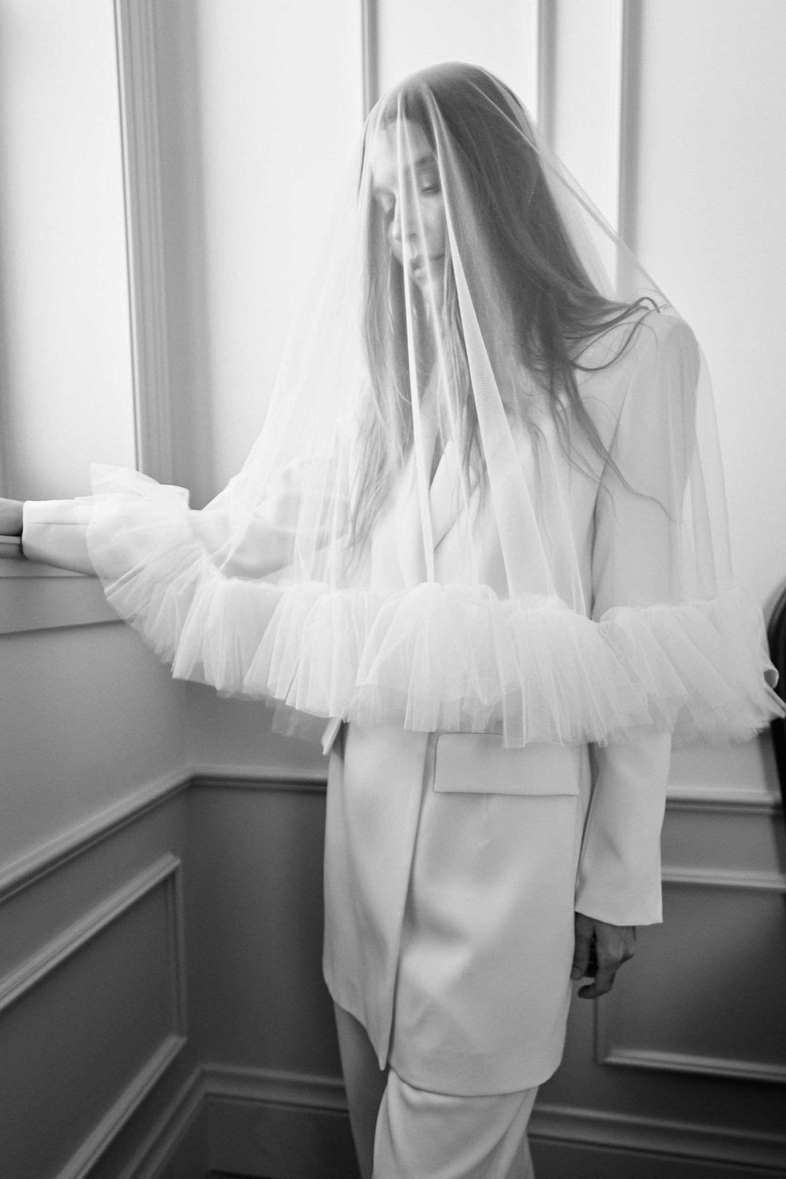 woman in veil by window looking down