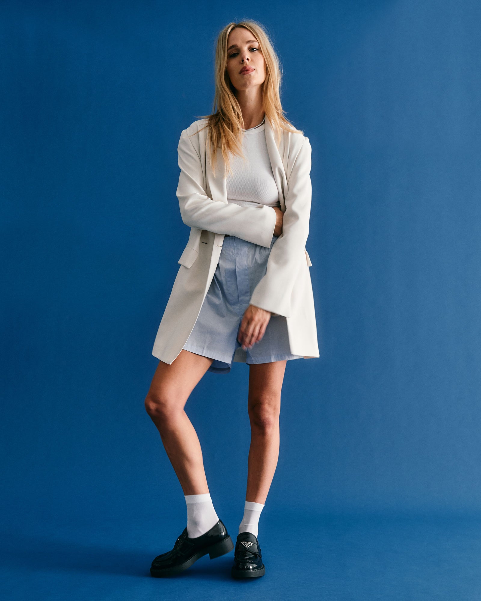woman in white oversized blazer and baggy shorts