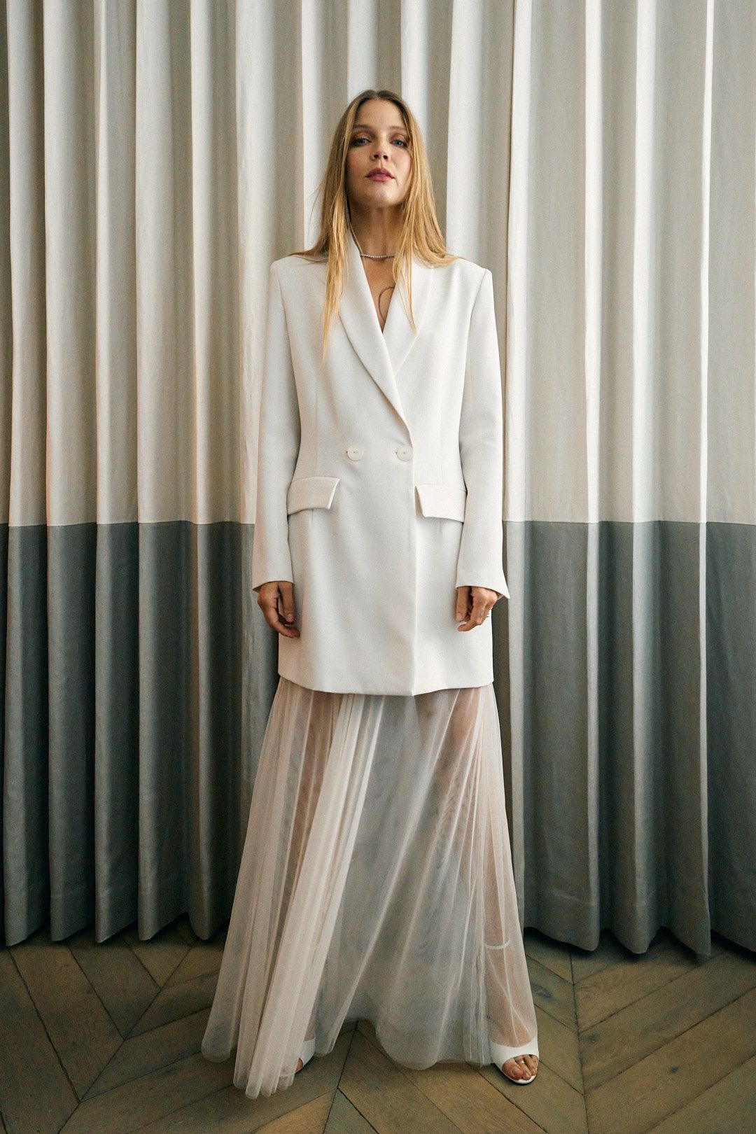 blonde woman in sheer dress with white blazer